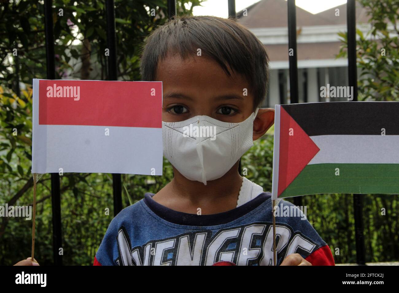 Yogyakarta, Yogyakarta, Indonesia. 21st May, 2021. A child holds Indonesian and Palestinian flags while demonstrating in support of Palestinians during a demonstration against Israel's attack on Gaza, in Yogyakarta, Indonesia on Friday, 21 May 2021. Indonesian Muslims hold a rally in support of a ceasefire announced last night after 11 days of fighting between the two sides that claimed many lives both in the Palestinian territories and in Israeli cities.Indonesian Rallies in Support of the Palestinian-Israeli Armistice Credit: Slamet Riyadi/ZUMA Wire/Alamy Live News Stock Photo