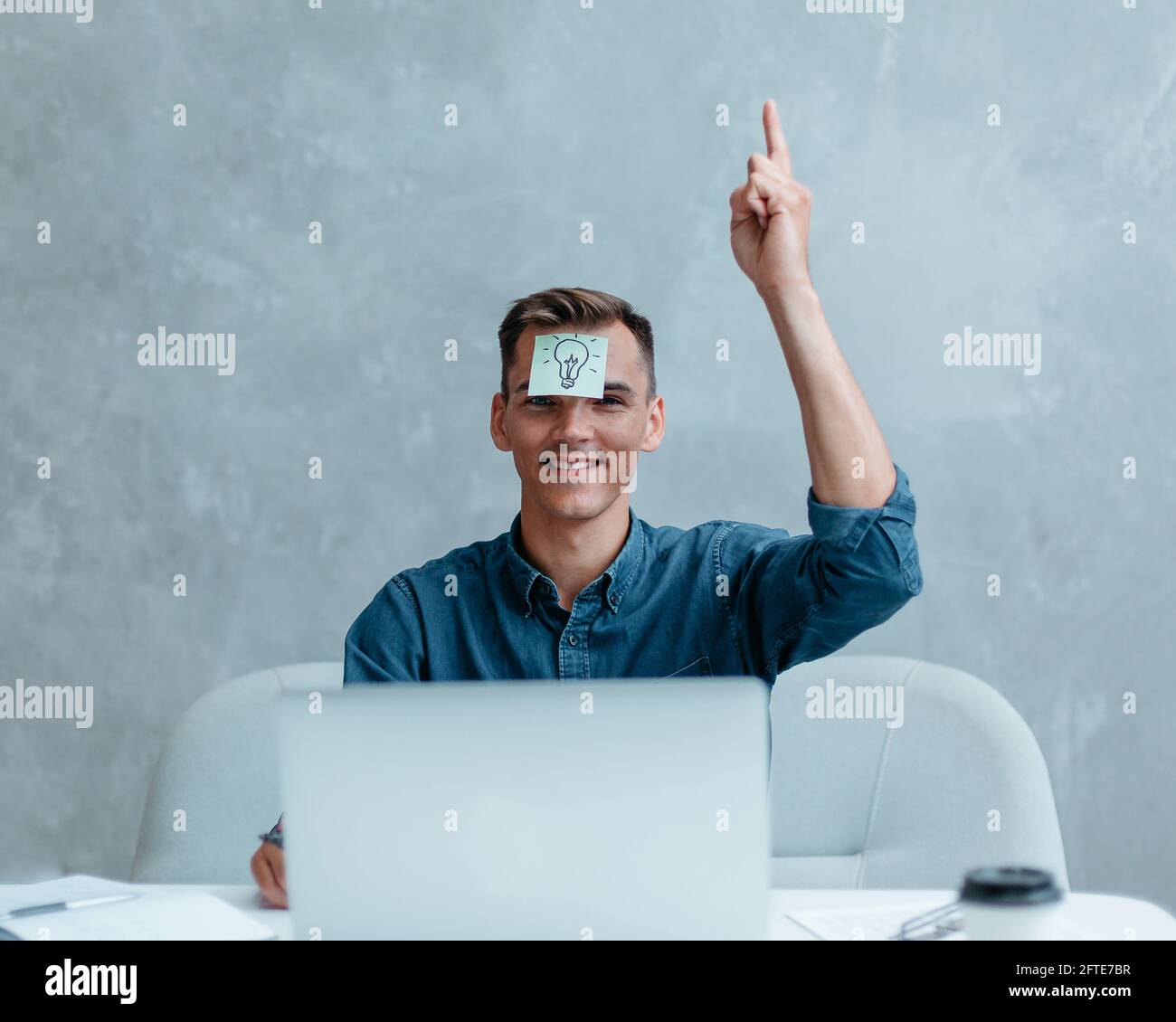 Satisfied man with raised hand thinking about good creative idea. Stock Photo