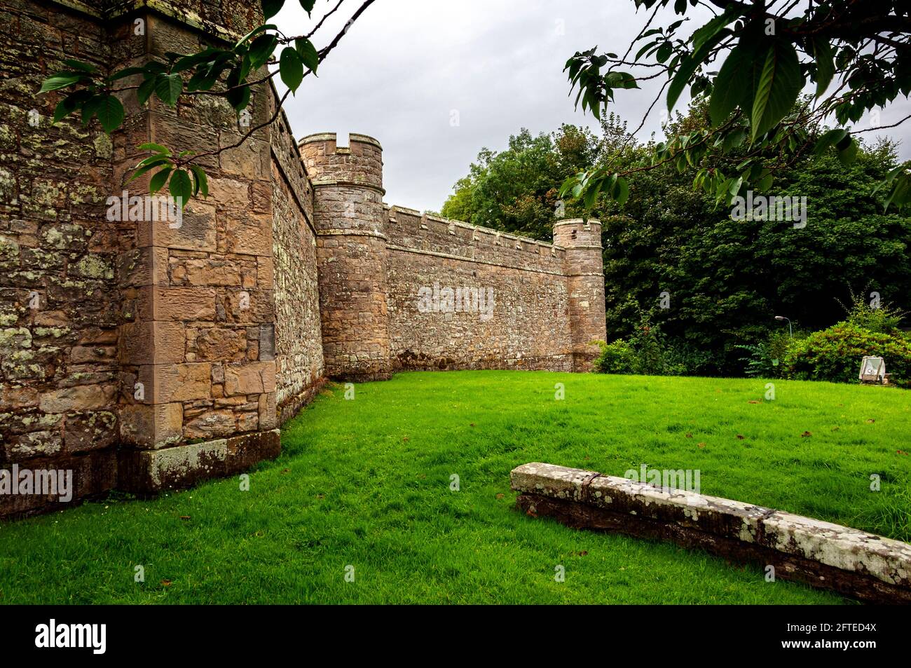 The castellated walls of Jedburgh Jail with sham battlements and small towers at angles enclosing a D-plan site built on the site of the former castle Stock Photo