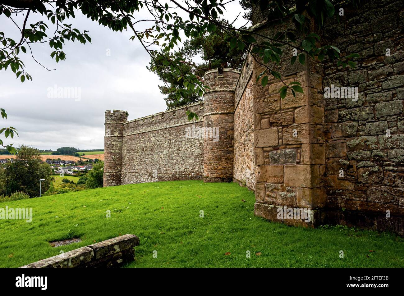 The castellated walls of Jedburgh Jail with sham battlements and small towers at angles enclosing a D-plan site built on the site of the former castle Stock Photo