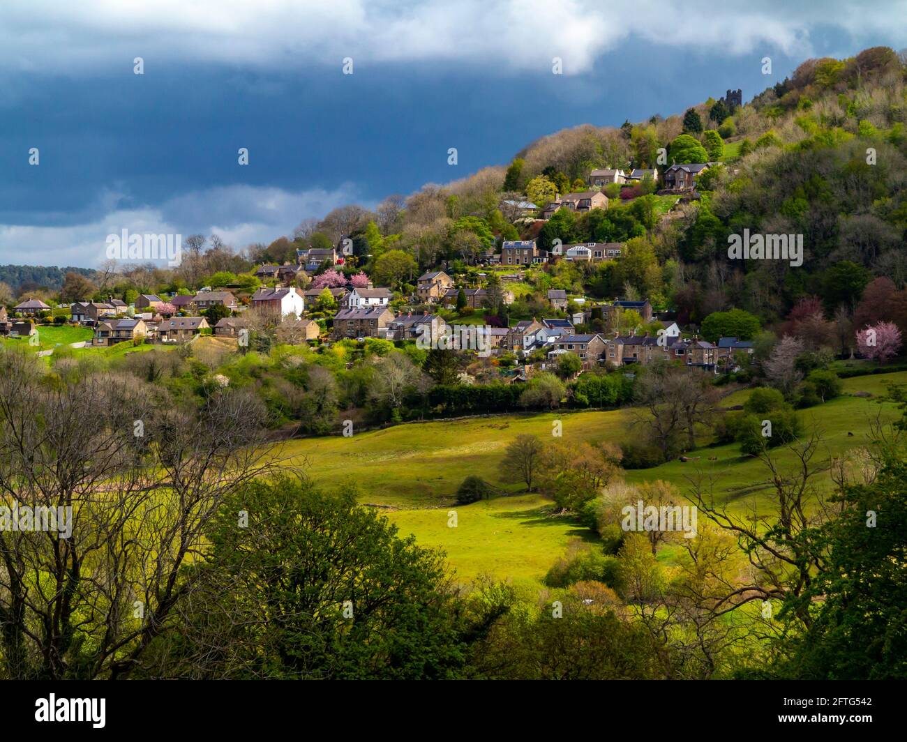 View over fields towards Starkholmes village from Matlock Bath in the Derbyshire Dales Peak District England UK with trees in spring colour. Stock Photo