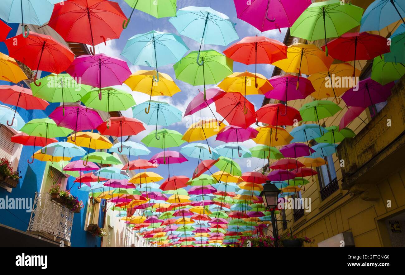 Colorful umbrellas under a blue sky by the Umbrella Sky Project on Rua Luís de Camões Stock Photo