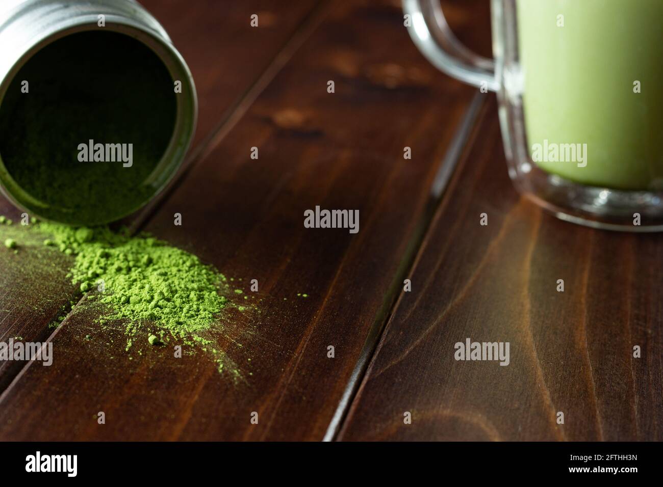 Matcha drink and powder on dark wood; Japanese green tea; serving; matcha on spoon; cup of green matcha tea Stock Photo
