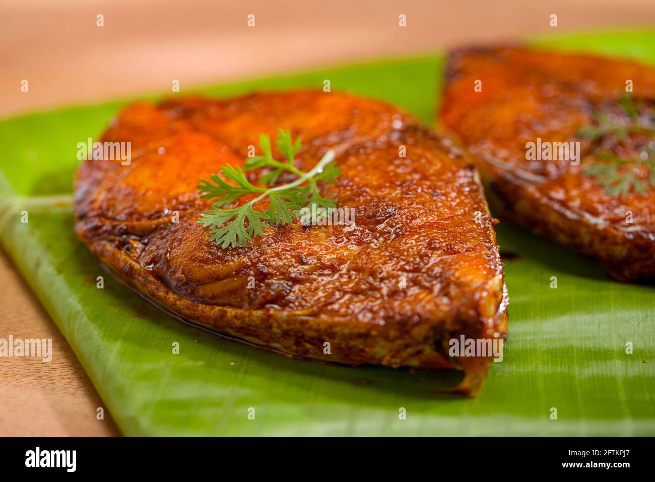 Seer fish fry arranged beautifully and garnished with coriander leaf, on banana leaf covered