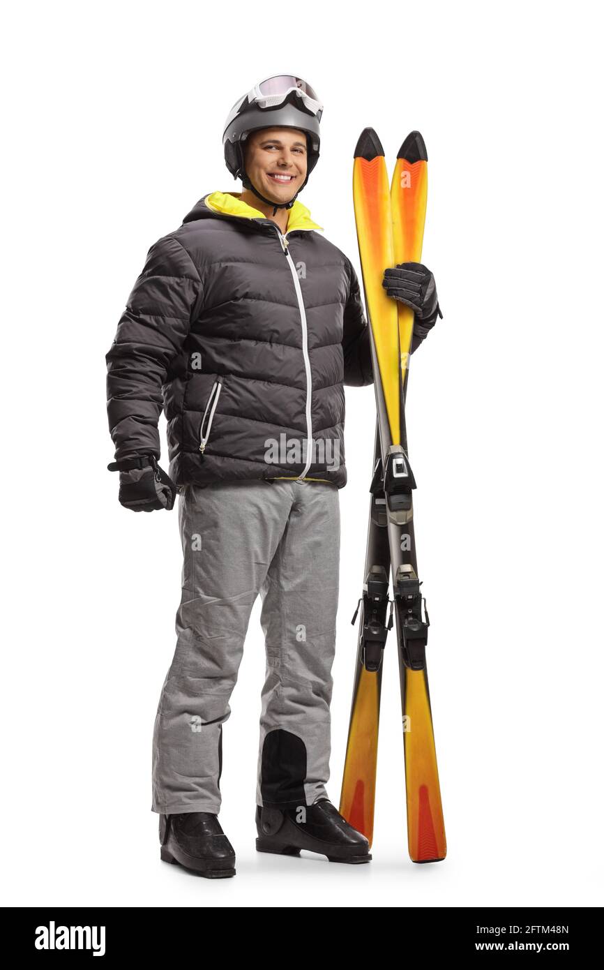 Full length portrait of a young man holding a pair of skis isolated on white background Stock Photo