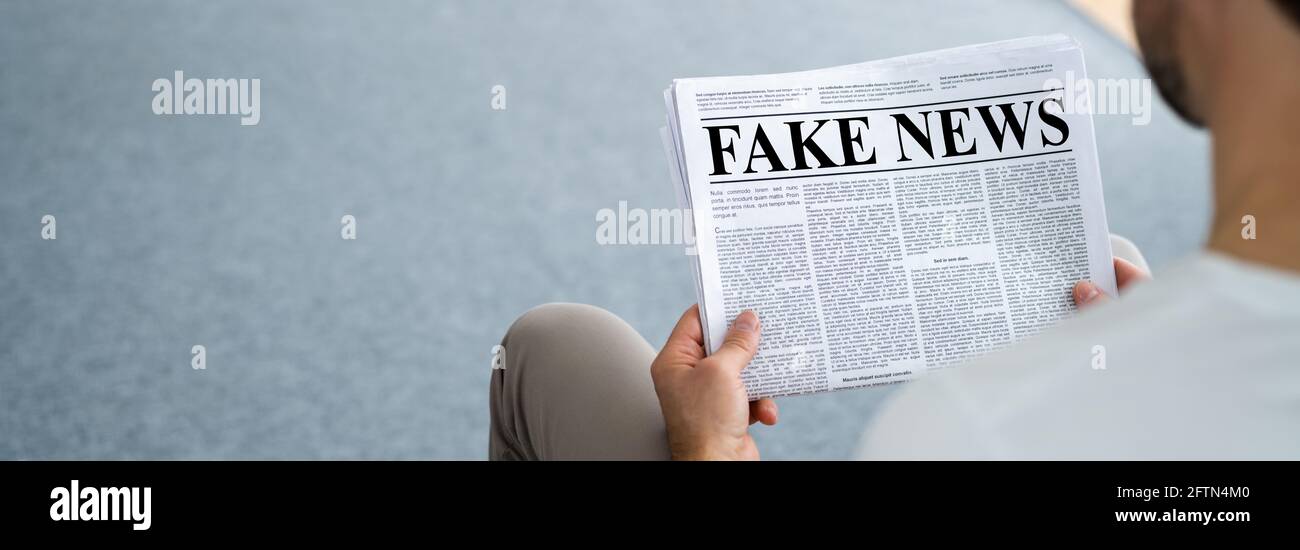 Businessman Reading Fake News Article On Newspaper In Living Room Stock ...