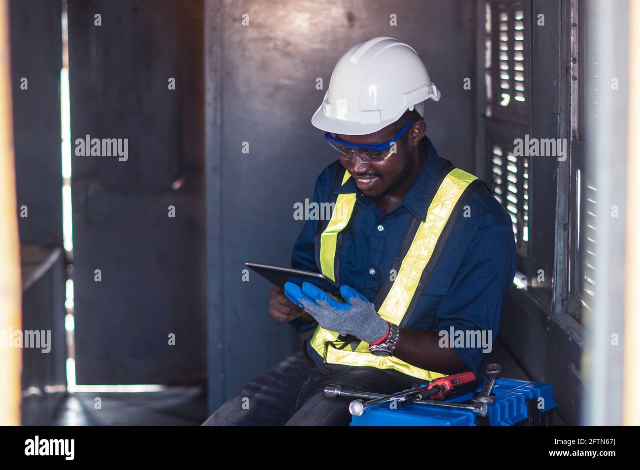 Industry engine technicians are using the tablet to research engine system within the control room Stock Photo