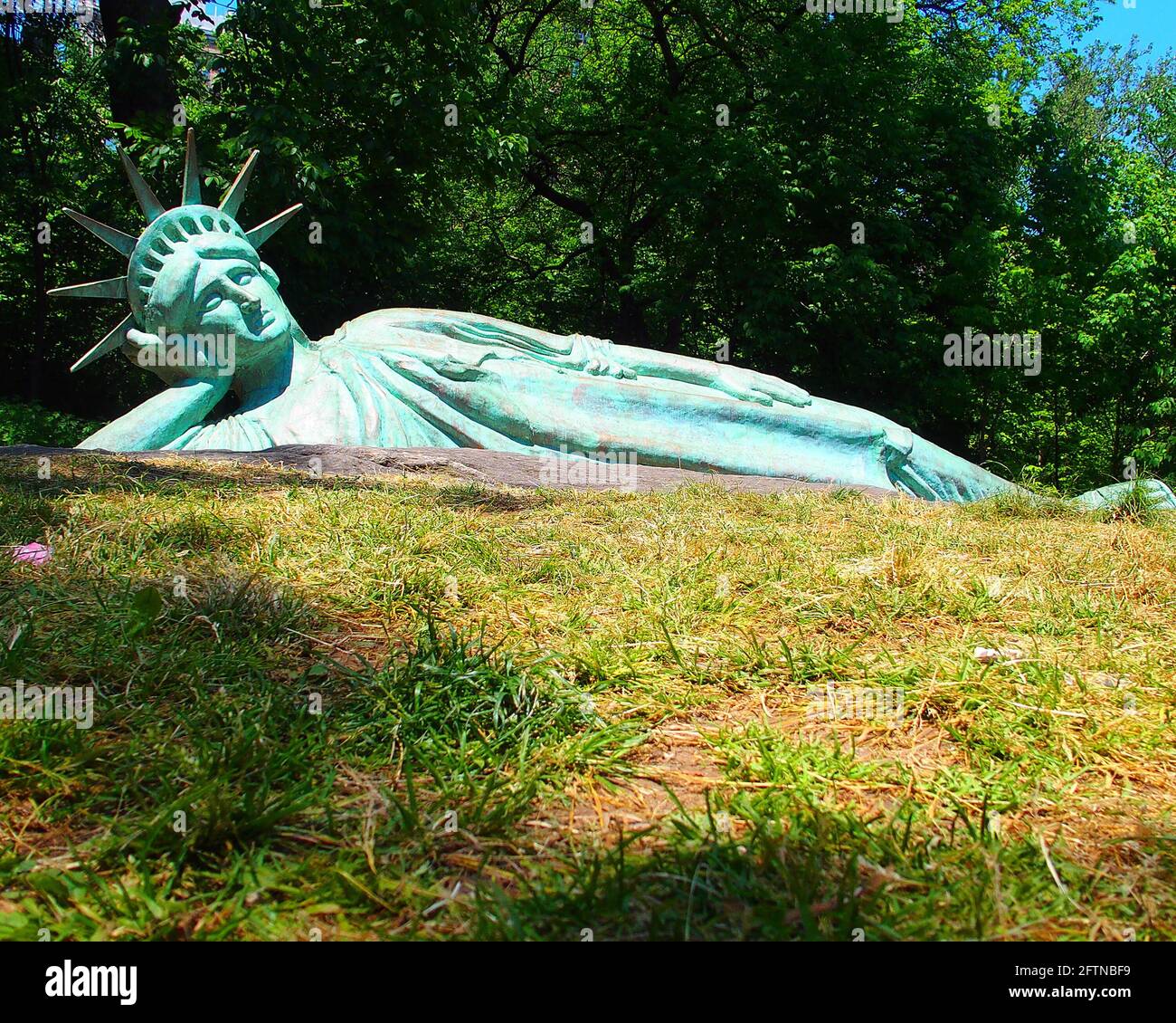 New York, New York, USA. 21st May, 2021. Artist Zaq Landsberg's sculpture entitled ''Reclining Liberty'' inside Morningside Park in New York City .The sculpture was created by Landsberg and features the Statue of Liberty posed on her side with her head propped up by her hand. The 25 foot long sculpture is covered in oxidized copper paint and features a steel crown and was created using wood, foam and plaster resin. Credit: Debra L. Rothenberg/ZUMA Wire/Alamy Live News Stock Photo