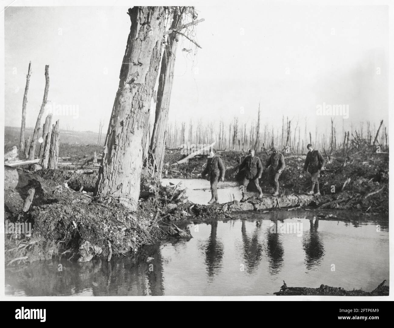 World War One, WWI, Western Front - Men cross an improvised bridge in the form of a tree trunk over water, France Stock Photo