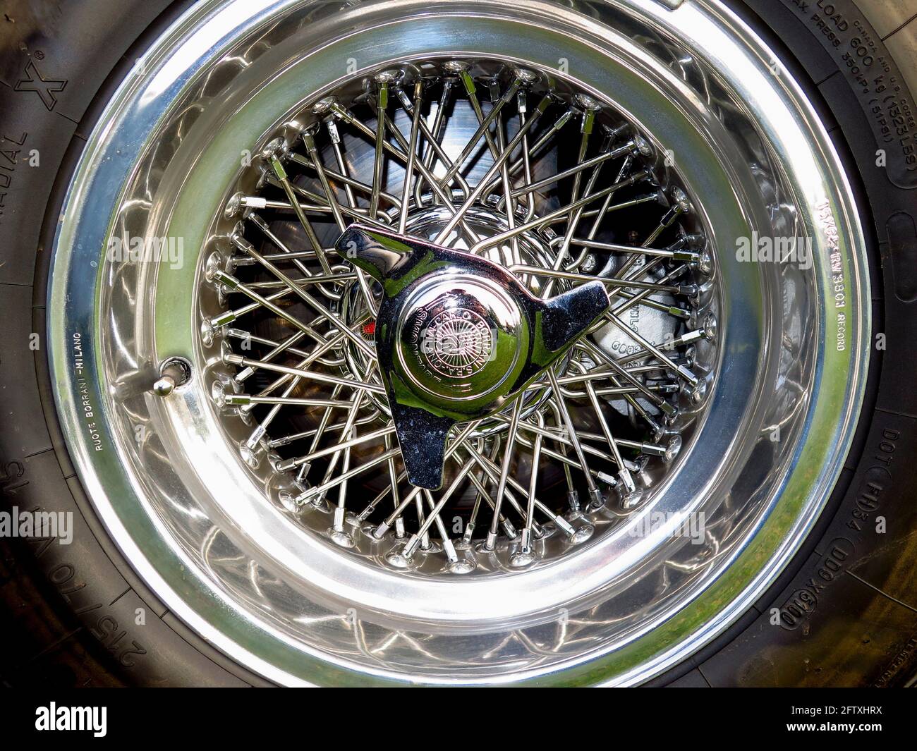 Chrome wire sports car wheel on vintage car Stock Photo