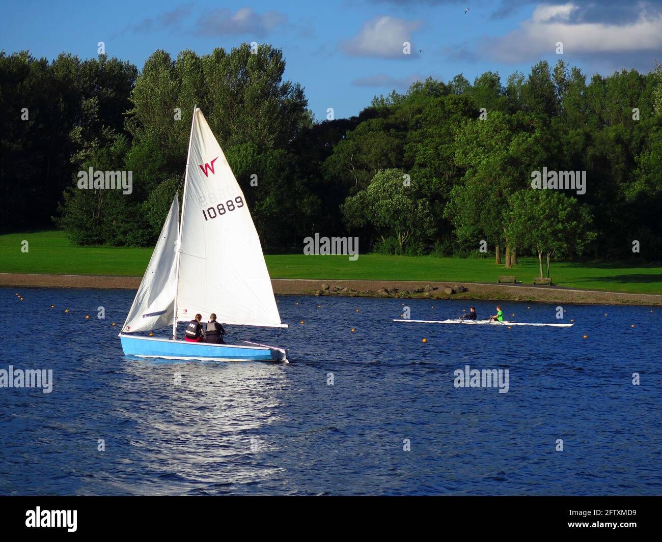 Dinghy and double scull on Strathclyde Loch Stock Photo