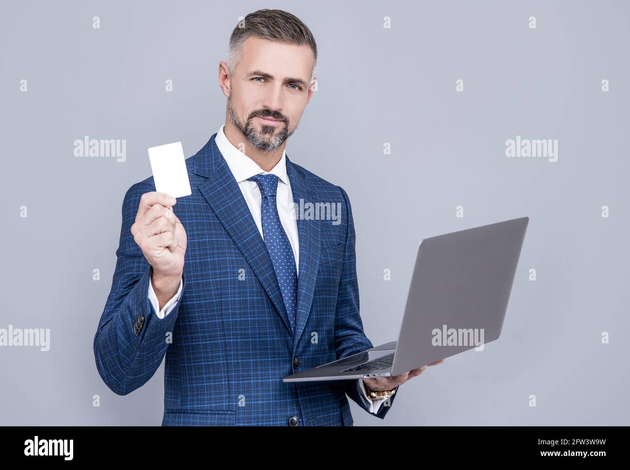 confident businessman man in businesslike suit hold laptop and debit card, shopping online Stock Photo