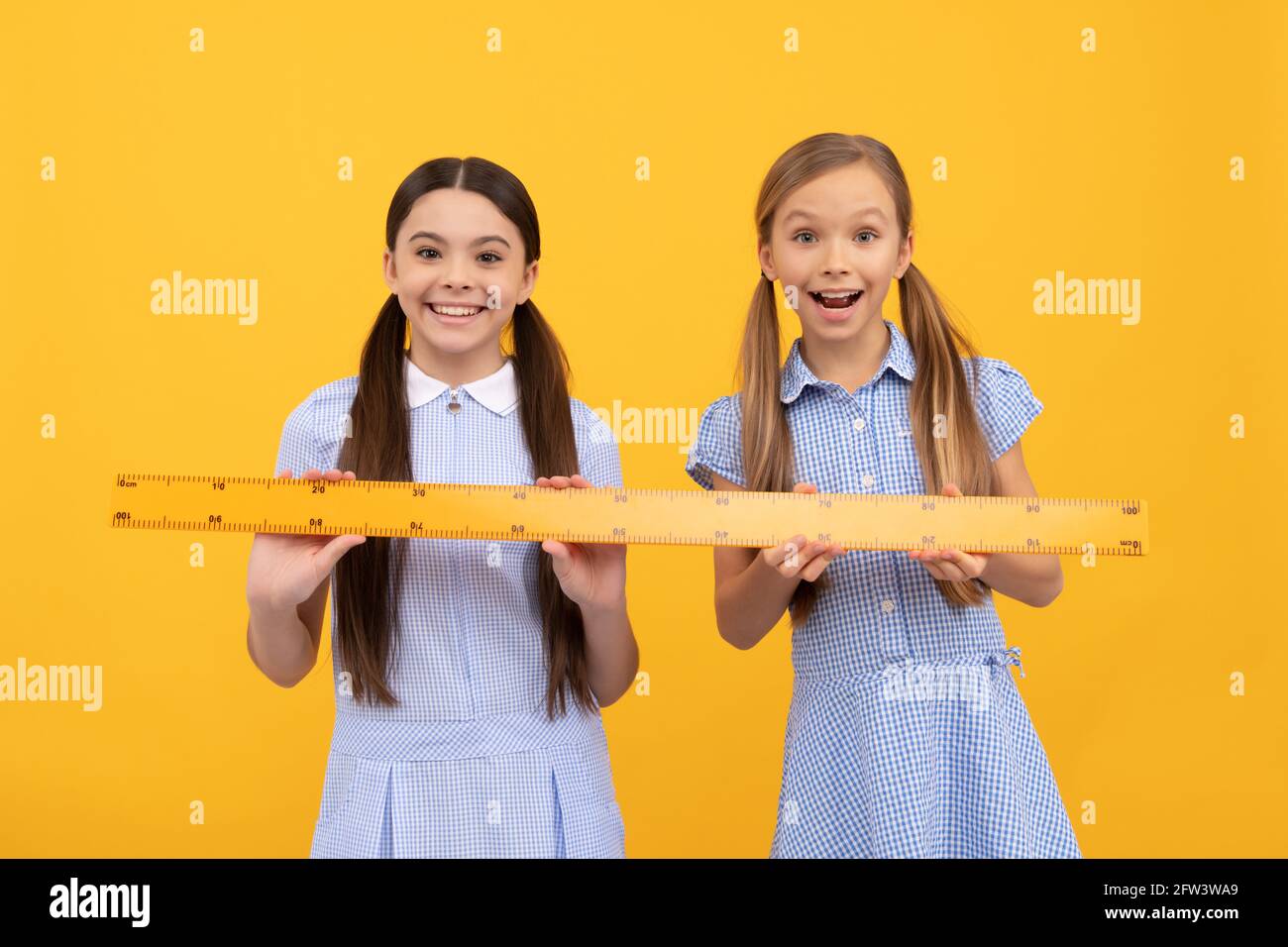 Ruler makes the drawing look better. Small child holding drawing instrument  on yellow background. Little girl using ruler for drawing straight lines.  Having geometry or technical drawing lessons Stock Photo - Alamy
