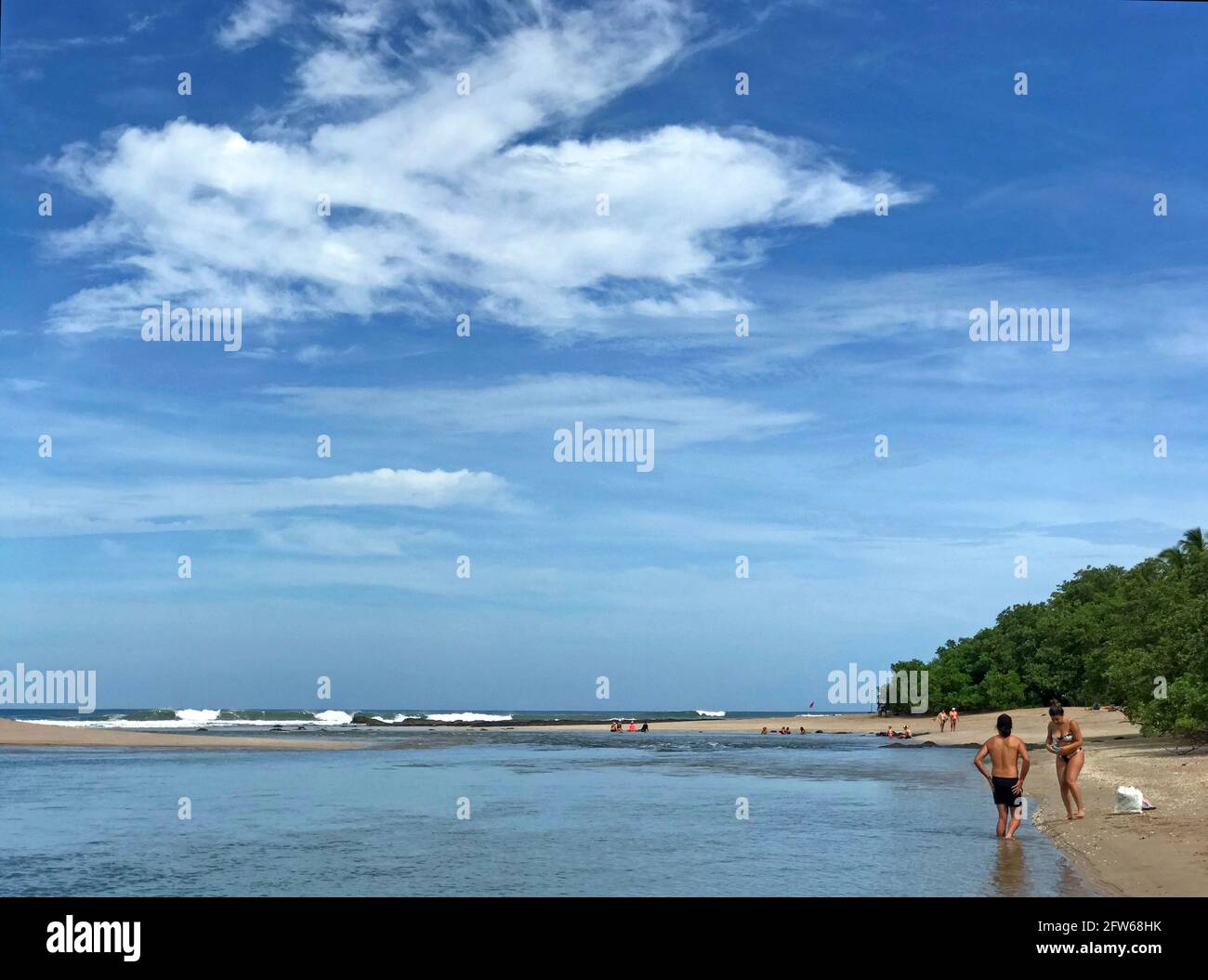 People bathing a river that is meeting with the Pacific Ocean at Tamarindo, Costa Rica. Stock Photo