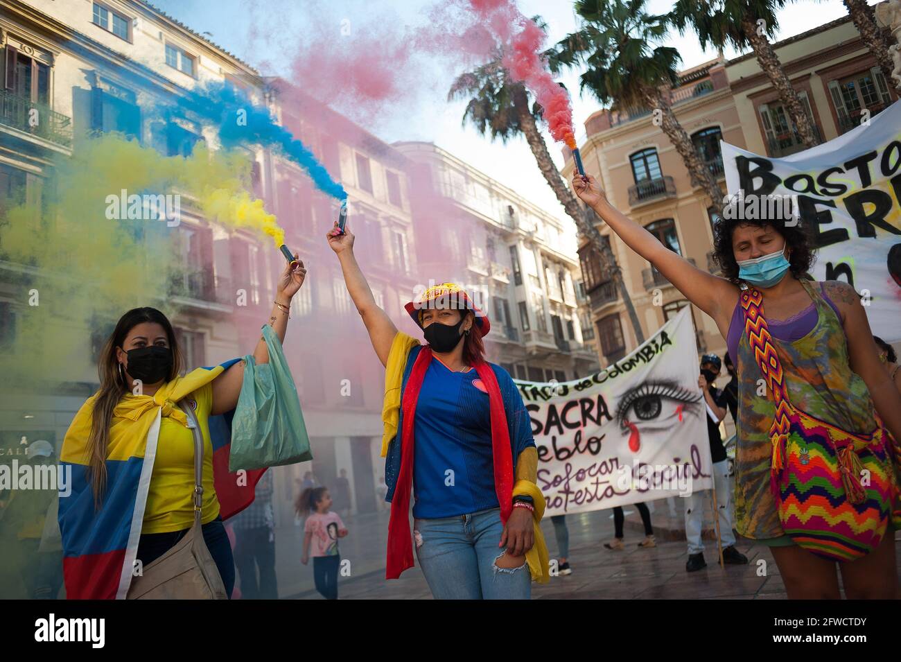 Malaga, Spain. 22nd May, 2021. Colombian protesters hold up flares during the demonstration at Plaza de la Constitucion squareColombian residents in Malaga take to the streets again in solidarity with the Colombians and against the government of President Iván Duque as negotiations continue between the Colombian government and the committee of the national strike after which protests and violent clashes erupted in the country. Credit: SOPA Images Limited/Alamy Live News Stock Photo