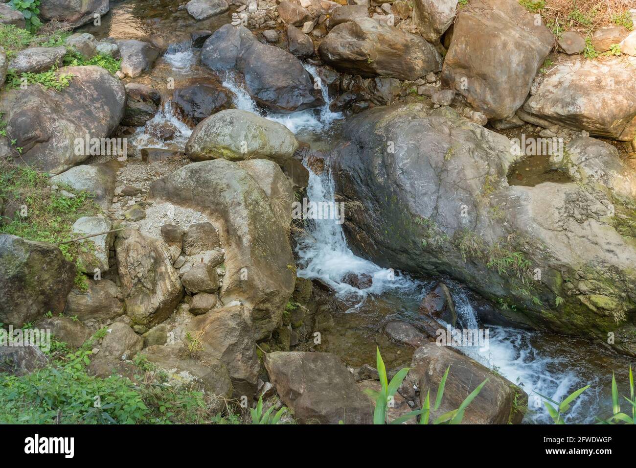 A huge rock shaped like an apple , called 'Apple Stone', with an waterfall passing through the famous rock. Image shot at Jhalong, Dooars, West Bengal Stock Photo
