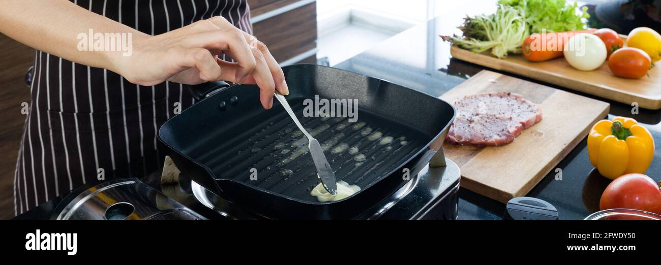 Chef putting butter in hot pan, preparing to grill the steak. The
