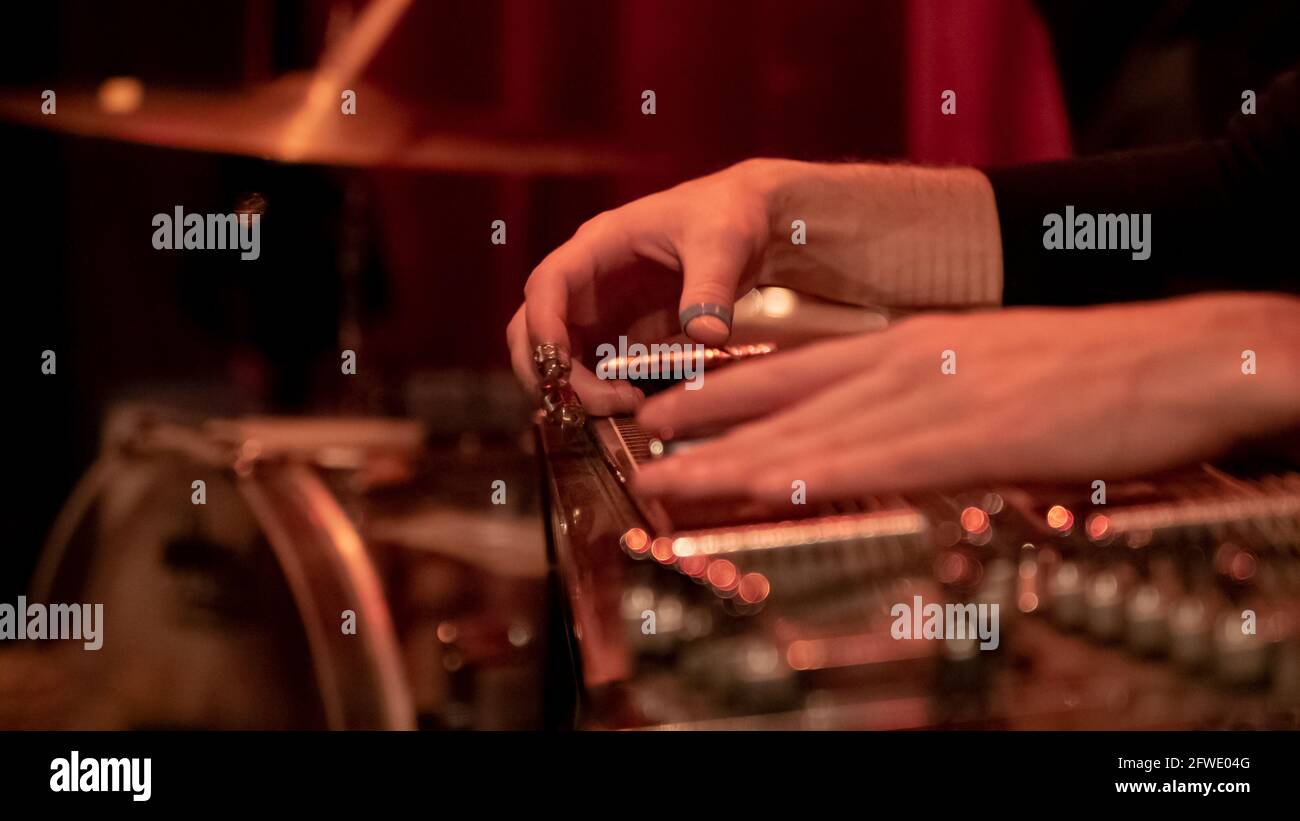 Close up of a musician playing lap steel, pedal guitar, slide guitar on stage. Stock Photo