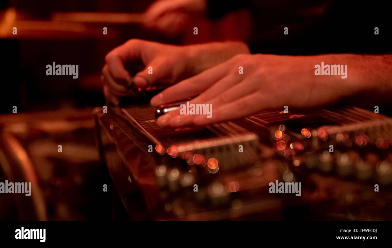 Close up of a musician playing lap steel, pedal guitar, slide guitar on stage. Stock Photo