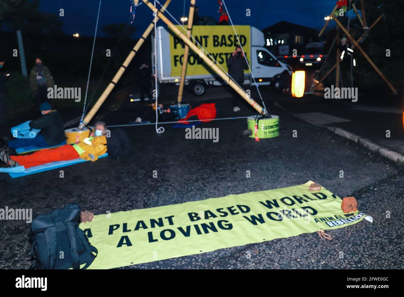 Coventry, UK, 22nd May 2021 Animal Rebellion blockades McDonalds distribution centres across the UK. In the early hours of the morning all four distribution centres which supply 1300 fast food outlets were targeted by 50+ protestors in a coordinated action. against animal agriculture. In Coventry two huge bamboo structures were erected with climbers in situ plus protestors locked on to concrete bases. Credit: Denise Laura Baker/Alamy Live News Stock Photo
