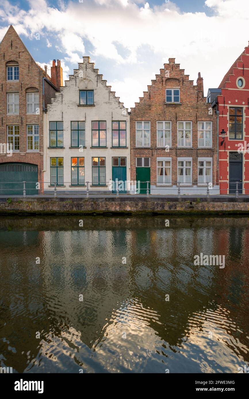 Twin facades but painted in different tones. Typical residential homes next to a channel in Bruges, Belgium. Stock Photo