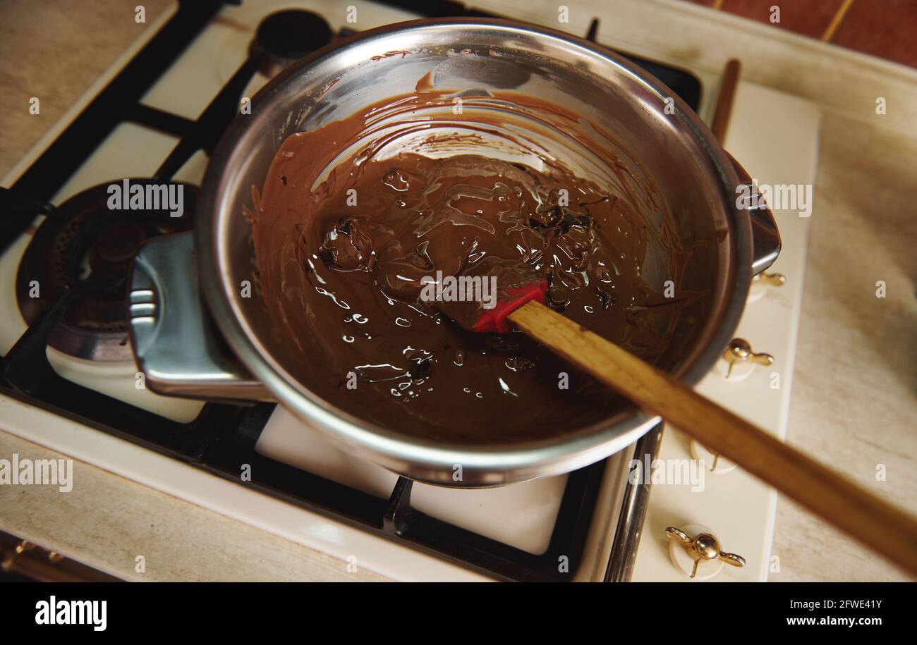 Heating and melting chocolate in a water bath before tempering it for