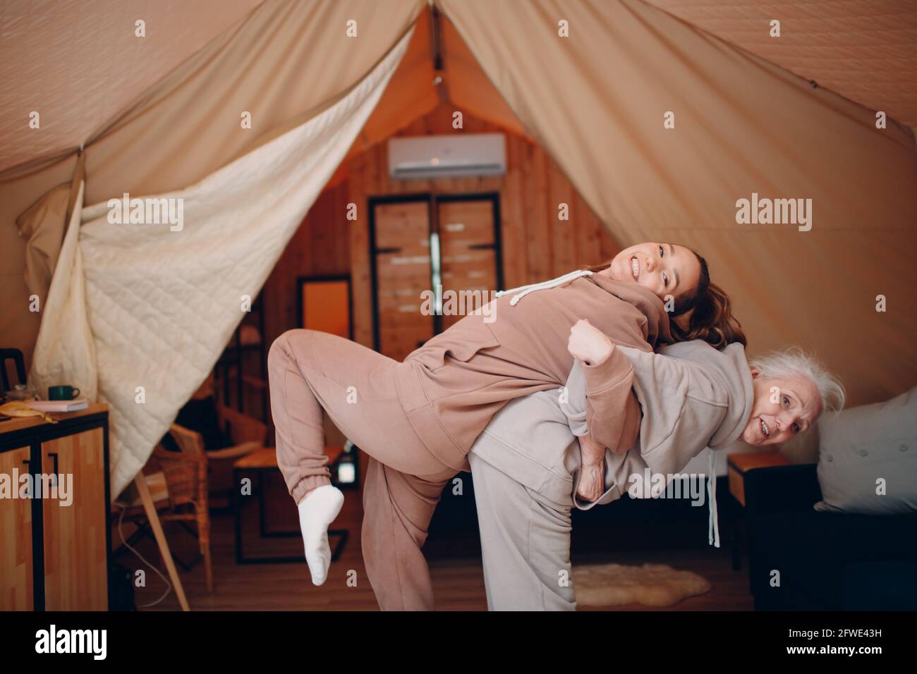 Woman senior and young relaxing at glamping camping tent. Women family  elderly mother and young daughter doing yoga and meditation indoor. Modern  zen-like vacation lifestyle concept Stock Photo - Alamy