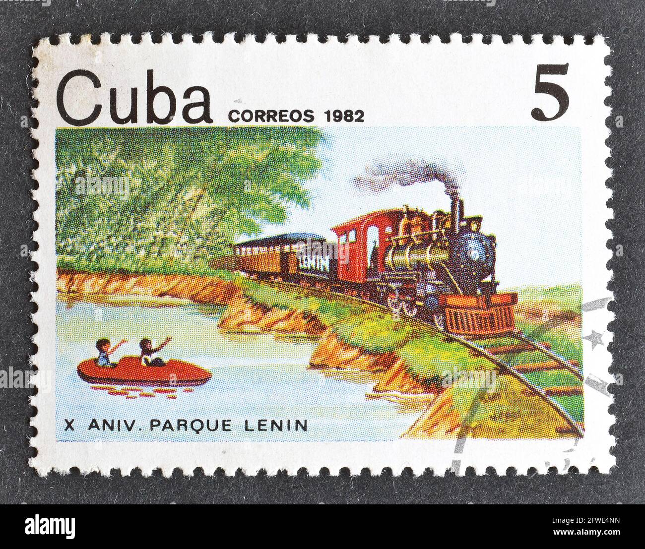 Cancelled postage stamp printed by Cuba, that shows Steam locomotive (1917) and boat on lake, circa 1982. Stock Photo