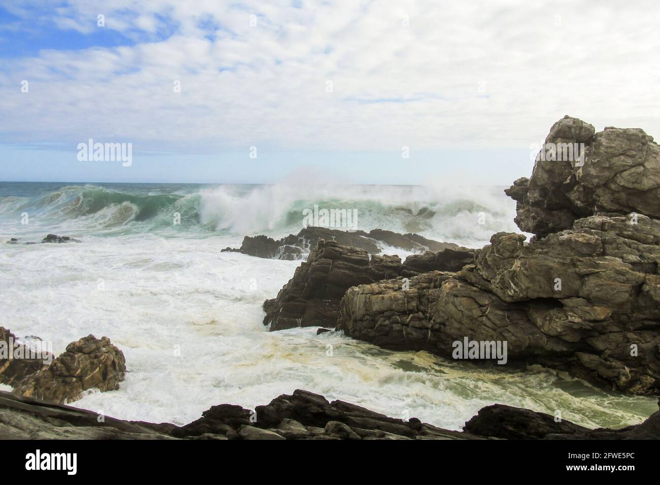 A rough tempestuous ocean along the rocky coastline of the Tsitsikamma Section of the Garden Route National Park in South Africa. Stock Photo