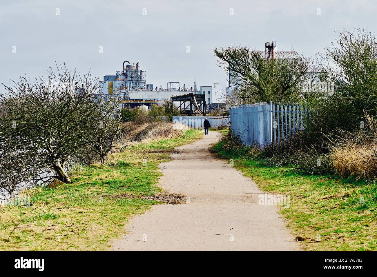 Public footpath running next to industrial plant and former ICI hillhouse site Stock Photo