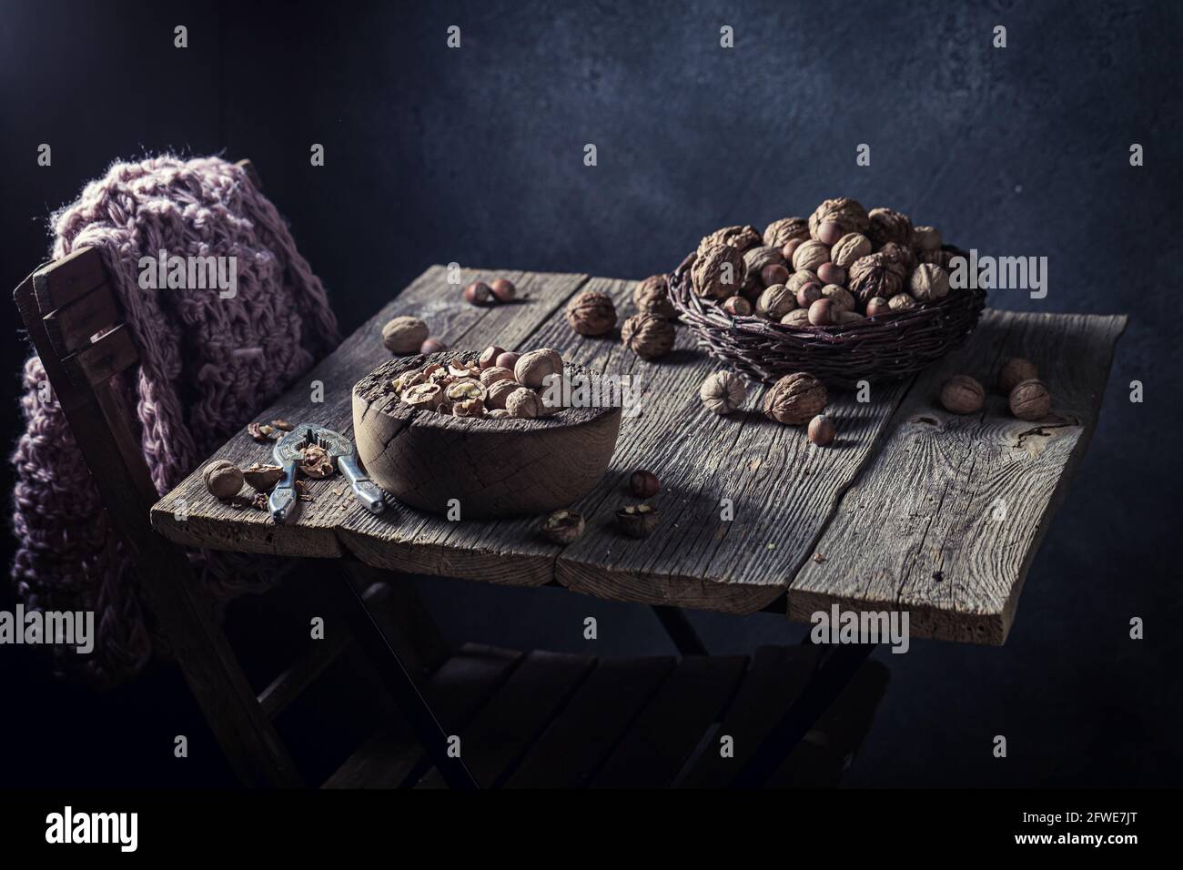 Various nuts and nutcracker. Walnuts and hazelnuts on the old table. Rustic table with walnuts and hazelnuts. Stock Photo