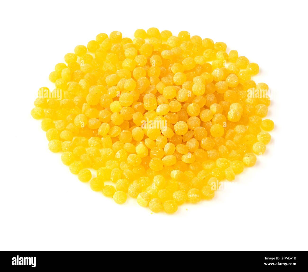pile of uncooked ptitim (Israeli couscous) closeup on white background