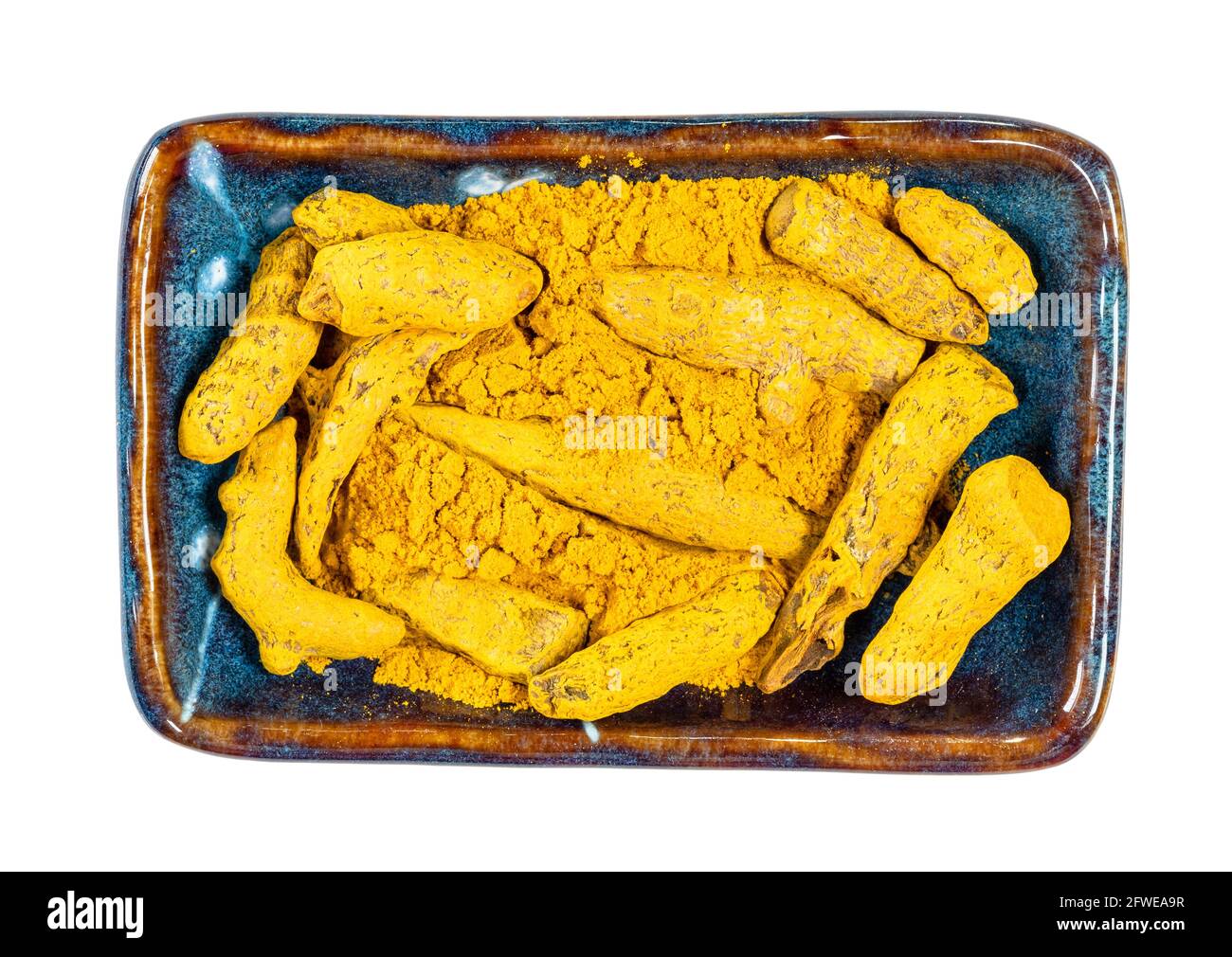 top view of Turmeric roots and powder (Curcuma Longa) in ceramic bowl ...