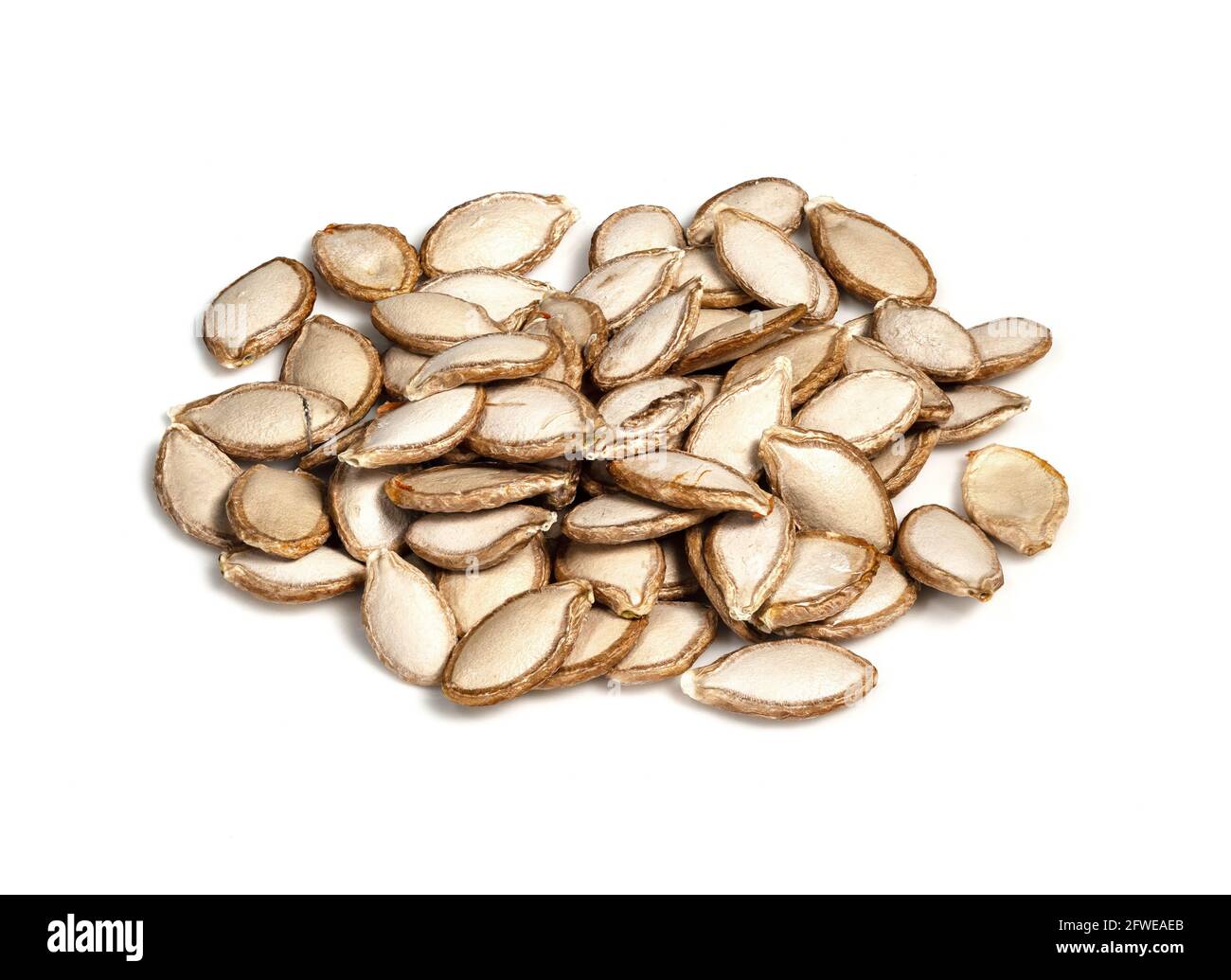 pile of unhusked Pumpkin seeds closeup on white background Stock Photo