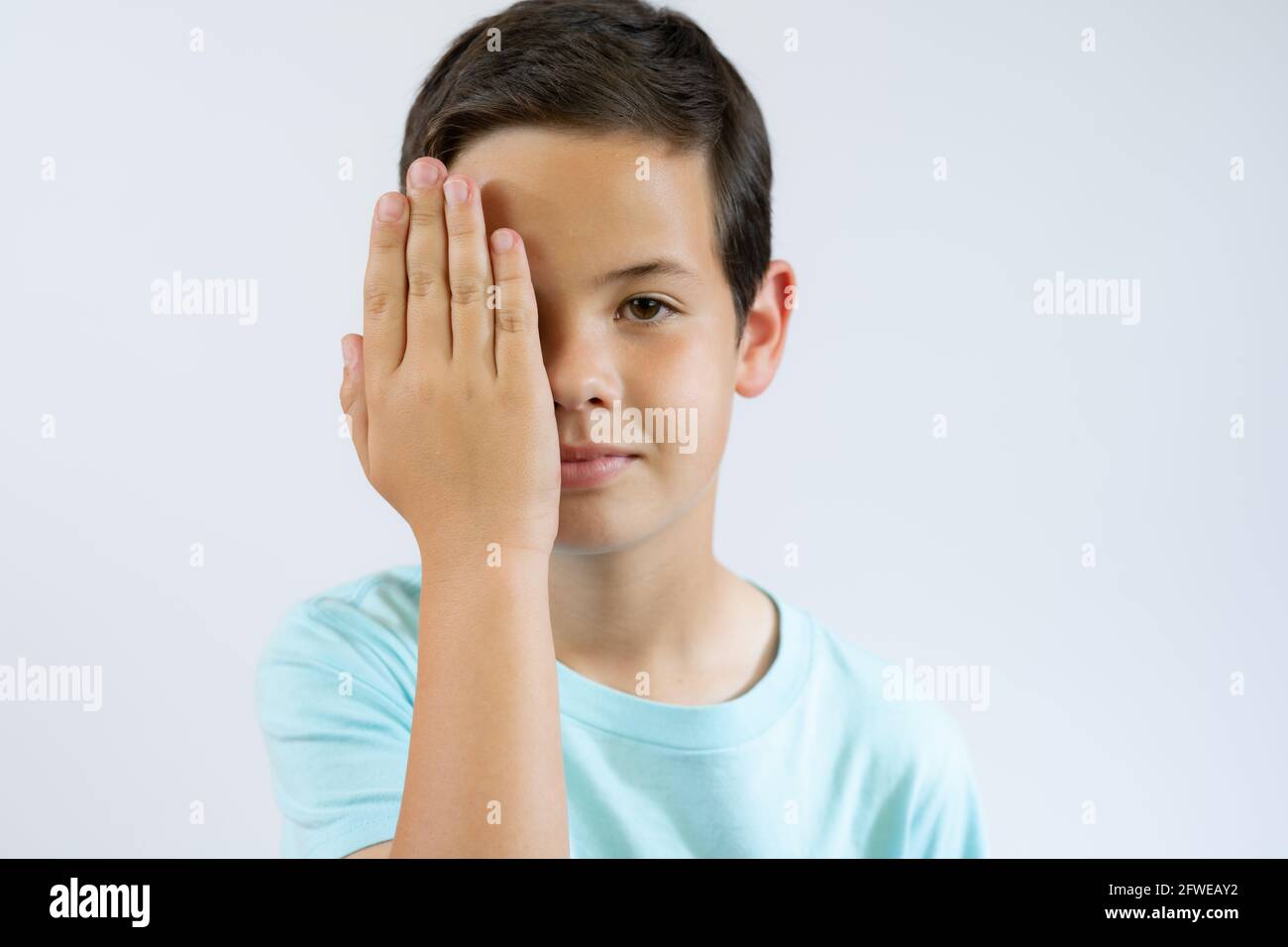 Little caucasian boy kid wearing casual clothes covering one eye with ...