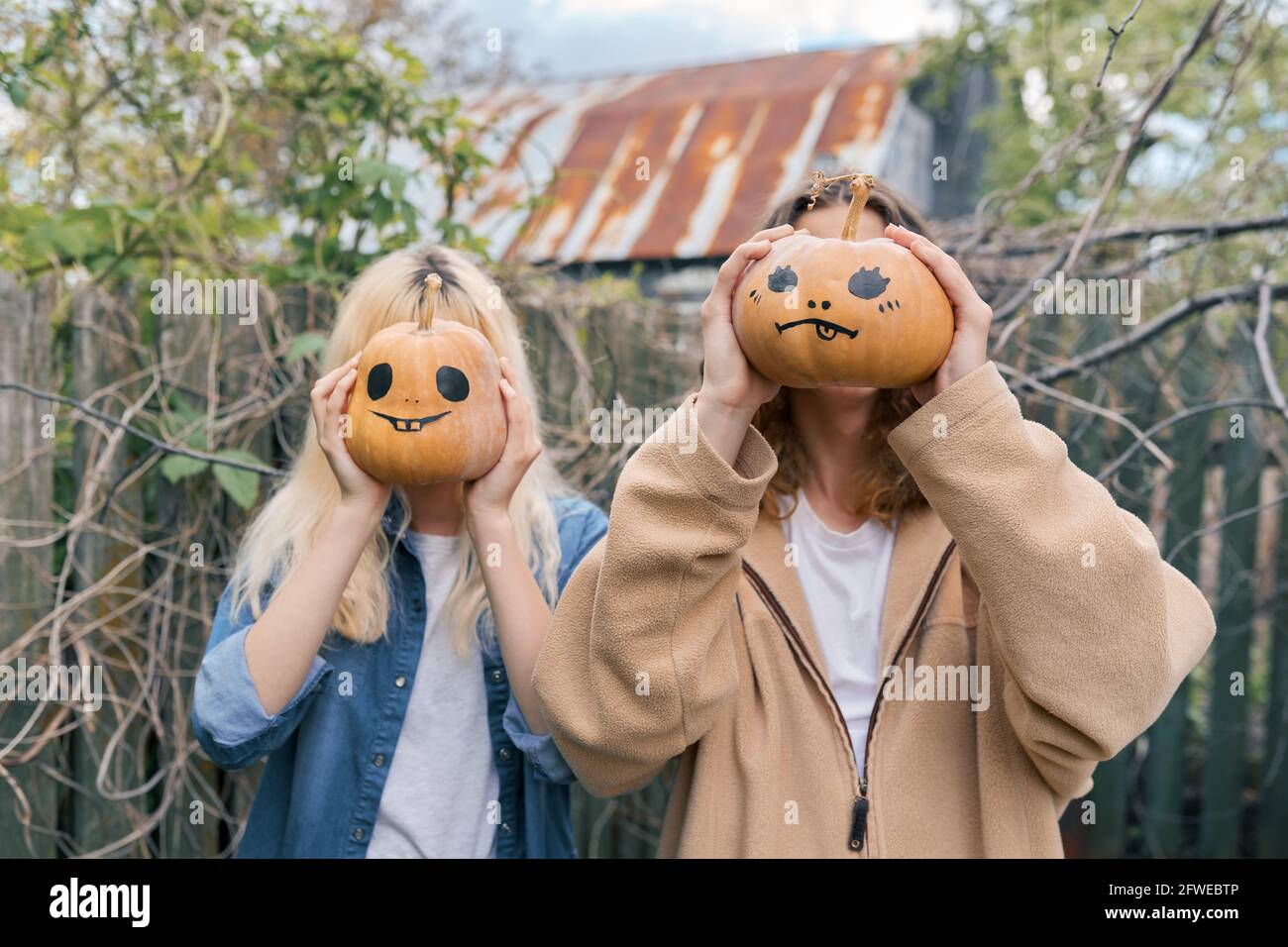 Couple of laughing teenagers with halloween pumpkins having fun Stock Photo
