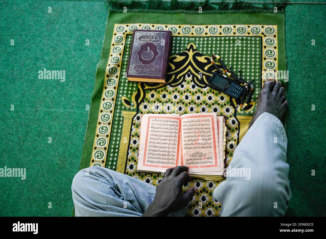 MALI, Kayes, mosque, muslim sitting on prayer carpet and reads a islamic book / Moschee, Muslim auf Gebetsteppich im Gebet Stock Photo