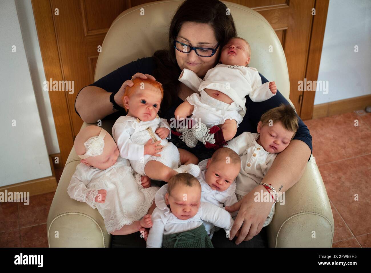 SPAIN, VALENCIA, 2019-04-28. Virginia poses with some of her reborn. Virginia is reborn artist and collector. She lives with her mother. SPAIN, VALENC Stock Photo