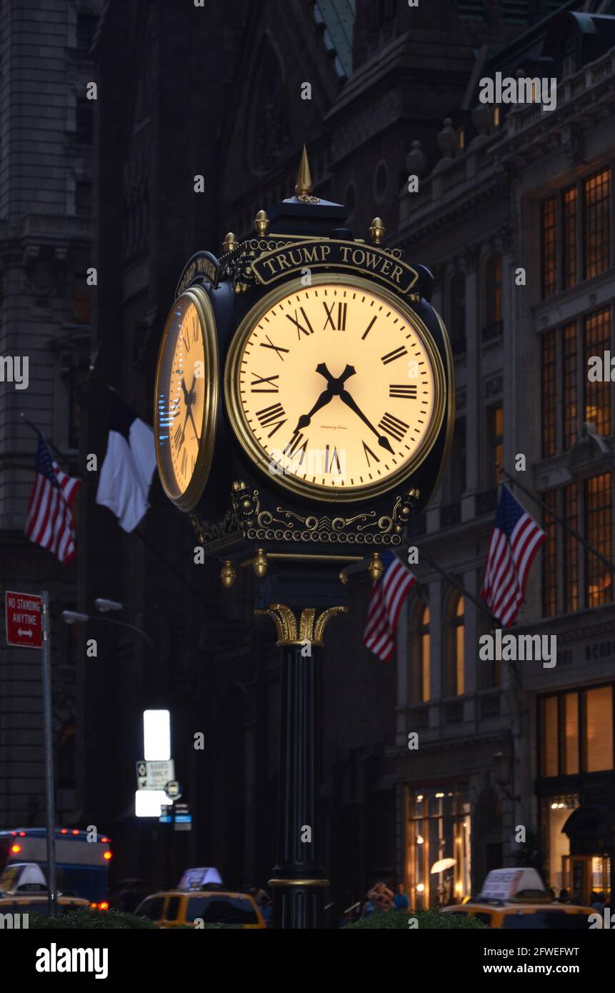 New York, USA - July 23 2013: Trump Tower clock at 5th Avenue in Manhattan with American flags in the background at night Stock Photo