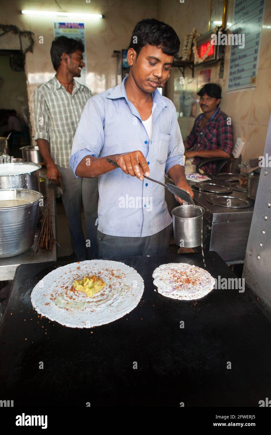 A cook preparing an onion dosa in a food hotel in Hyderabad, India Stock Photo