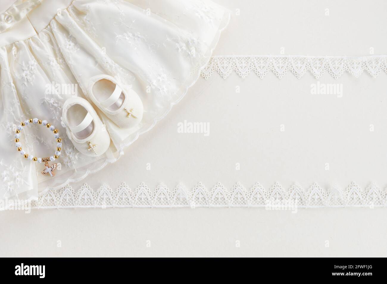 Christening background with baptism baby dress, shoes, and cross on
