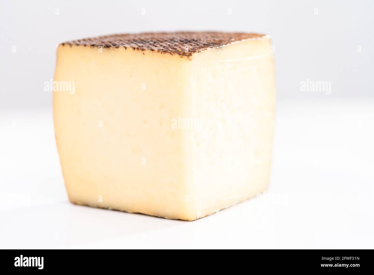 Large slice of aged Manchego cheese on a white background Stock Photo ...