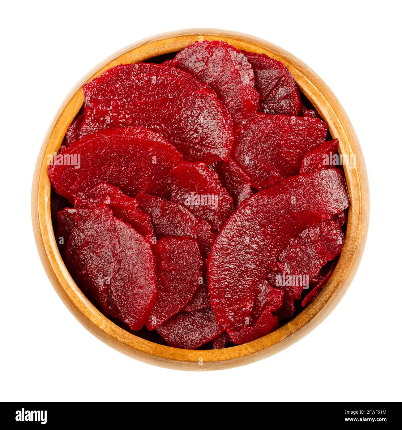 Sliced pickled beetroot slices, in a wooden bowl. Cooked, cut and preserved deep red beets, used as salad or added to a meal. Close-up, from above. Stock Photo