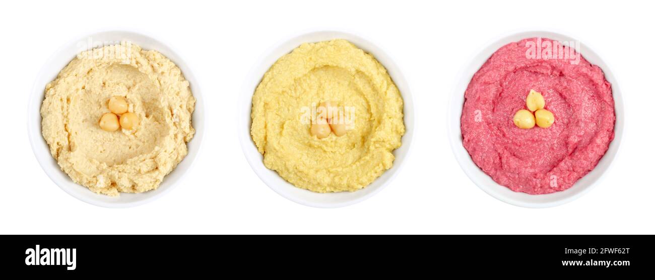 Hummus dips, in white bowls. Middle Eastern dip, a spread made of cooked, mashed chickpeas, blended with tahini, lemon juice and garlic. Stock Photo