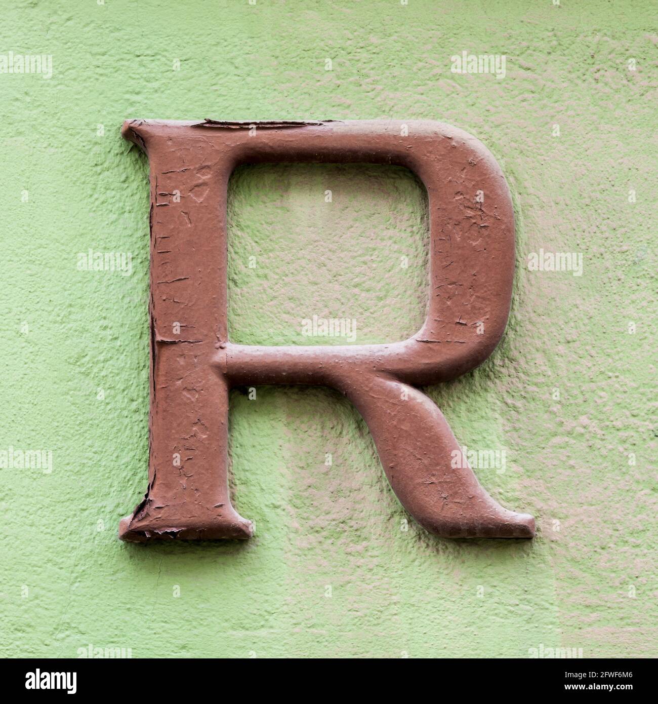 Brown letter R on green house wall Stock Photo