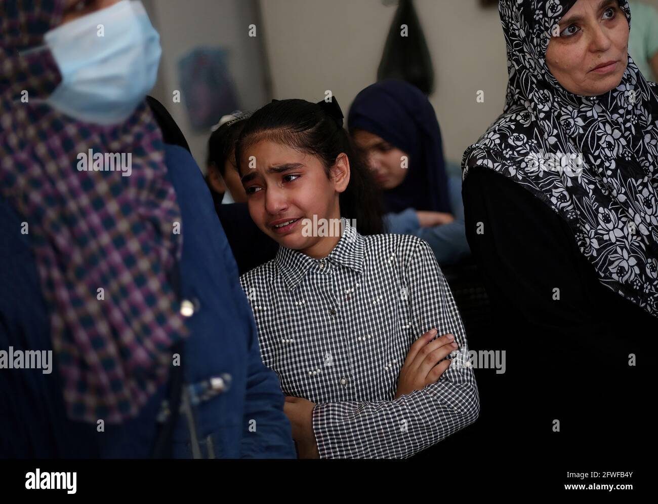 A Palestinian girl cries during the funeral of those members of the Ezz ...