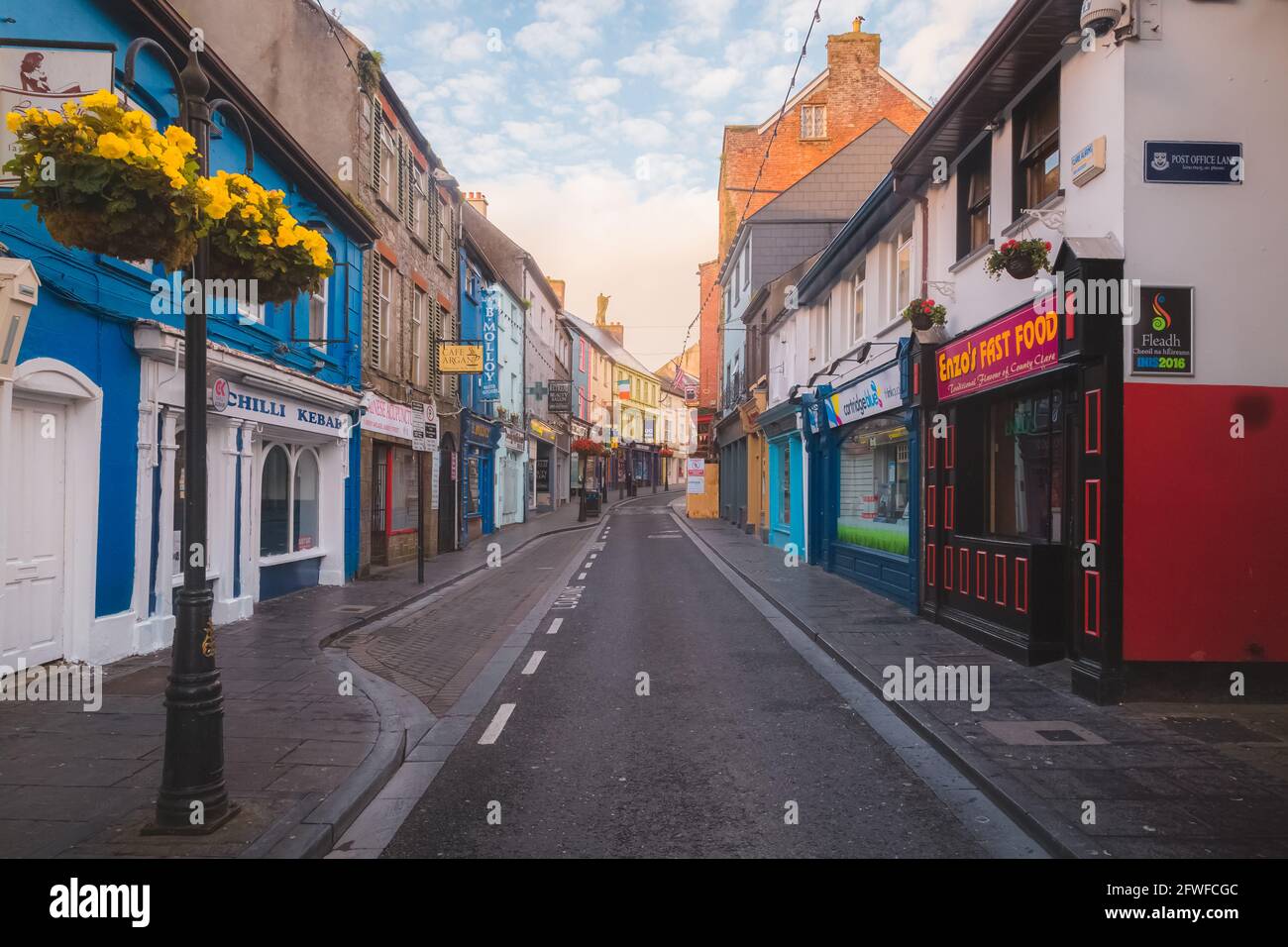 Ennis, Ireland - September 10 2016: The narrow Parnell street in the quaint, charming old town of Ennis, Ireland at with golden sunset or sunrise ligh Stock Photo