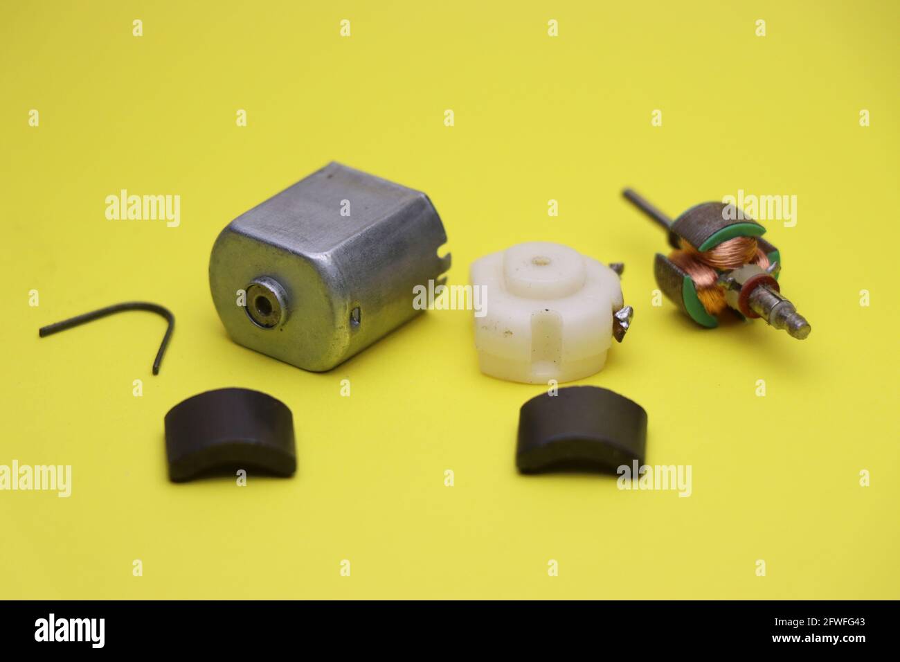 Break down of dc electric motor with all of its parts isolated on