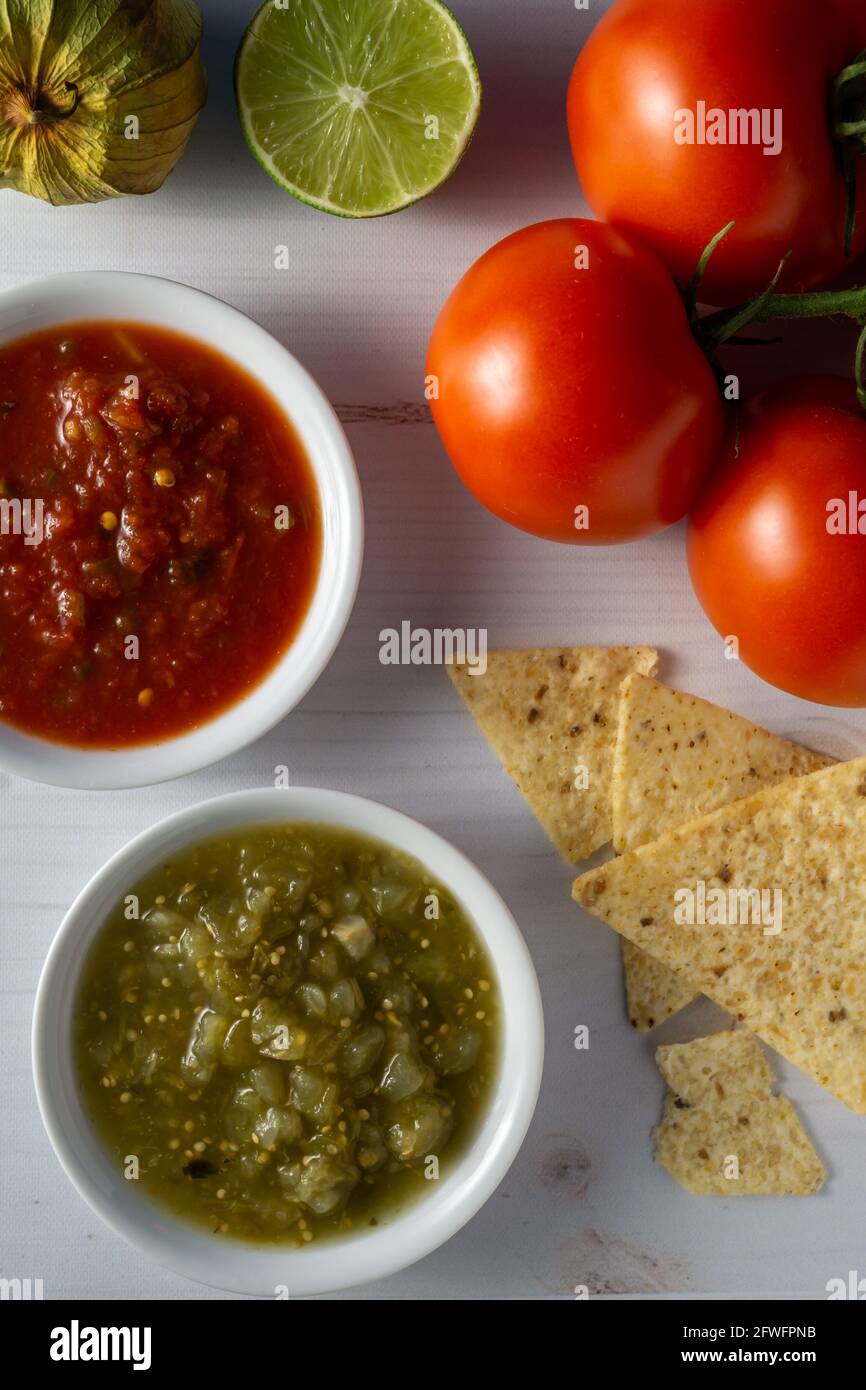 Corn tortilla chips and salsa with raw ingredients. Stock Photo
