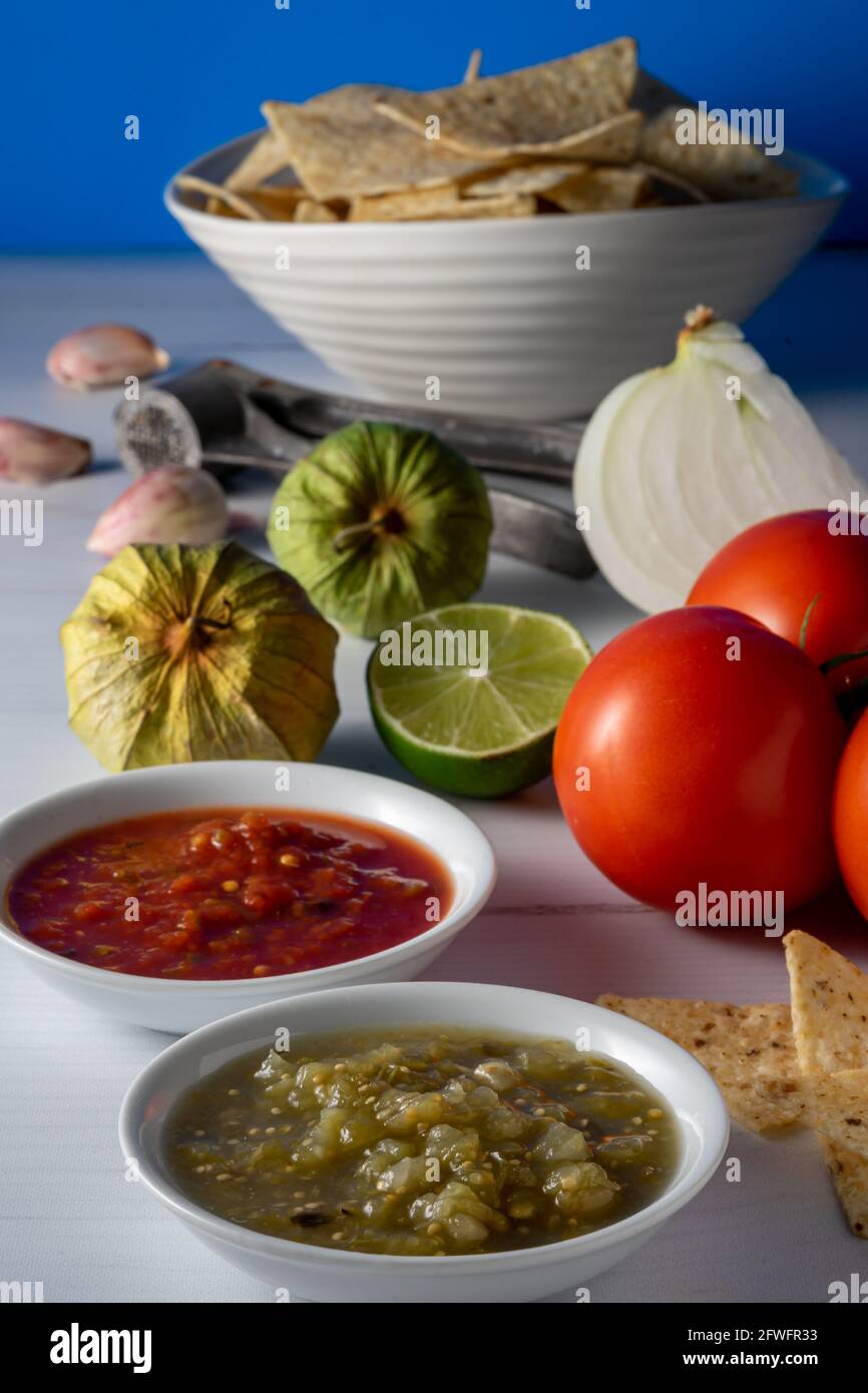 Corn tortilla chips and salsa with raw ingredients. Stock Photo